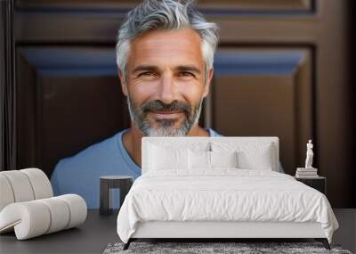 a man with a beard and gray hair is smiling and wearing a blue shirt Wall mural