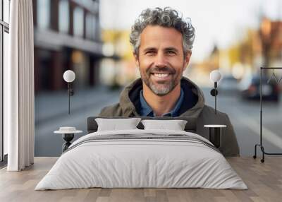 a man with a beard and gray hair is smiling and wearing a green jacket Wall mural