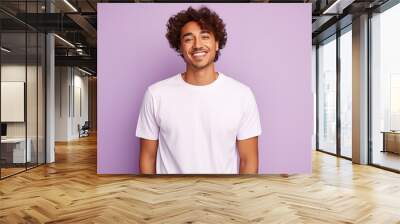 A man with a white shirt and curly hair is smiling at the camera Wall mural