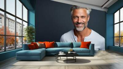 A man with a white shirt and gray hair is smiling Wall mural