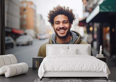 A man with curly hair is smiling and wearing a green jacket Wall mural