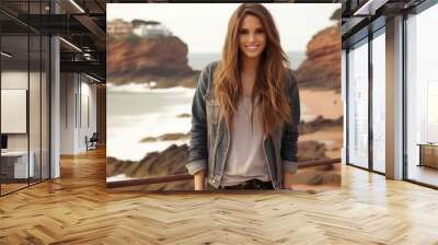 A woman with long brown hair is smiling and posing for a picture on a beach Wall mural