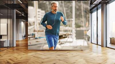 Active senior man jogging on a sunny day Wall mural