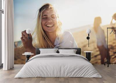 Beautiful girls in a summer day having fun on the beach, selective focus. Wall mural