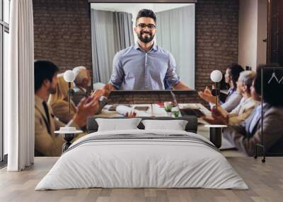 Business people looking at projector during video conference in office Wall mural