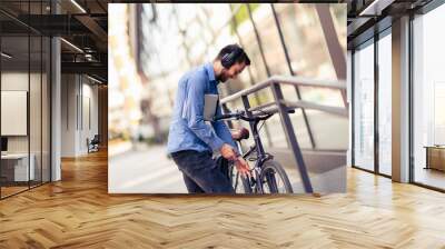 Businessman on bicycle using hands free listening for music. Business, work, and people concepts. Wall mural