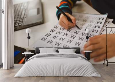 Child practicing writing at home. Wall mural