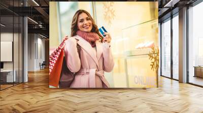 Christmas Shopping. Beautiful happy woman with credit card and shopping bags Wall mural