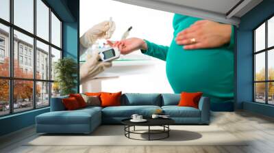 Close-up of a pregnant woman having her blood sugar/ glucose checked. Wall mural