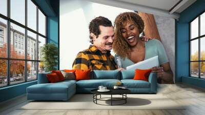 Couple feeling entertained while watching tablet. Wall mural