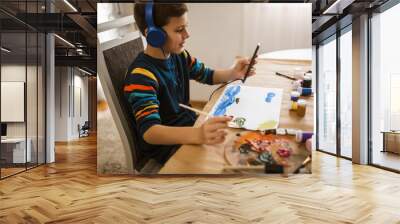 Cute little boy painting a picture in home studio Wall mural