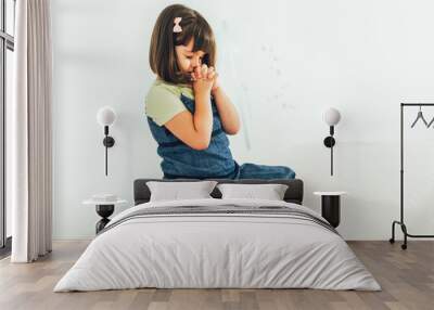 Cute little girl praying at home Wall mural