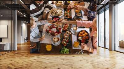 Family gathered in a restaurant to eat delicious food. They eat a variety of tasty foods. Wall mural