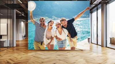 Group of friends having fun near the sea on vacation Wall mural