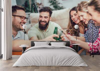 Group of happy young friends having fun and drinking beer in home interior Wall mural