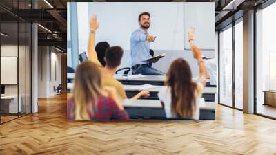 Group of students raising hands in class on lecture Wall mural