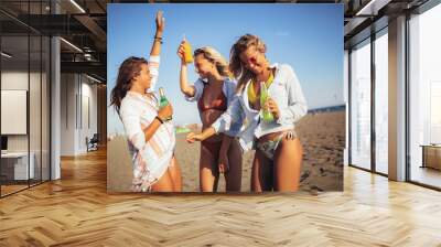 Group of three beautiful attractive young women having fun on the beach. Wall mural