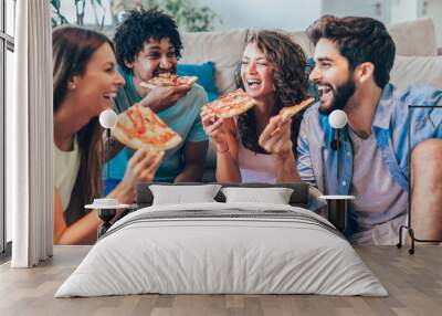 Group of young friends eating pizza.Home party. Wall mural