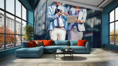 Handsome man and beautiful woman as business partners using digital tablet outdoor Wall mural