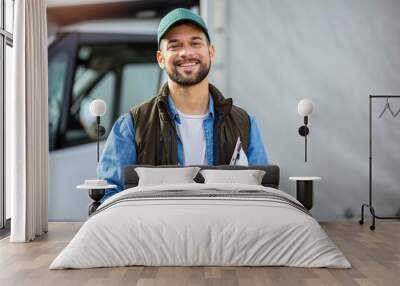 Happy confident male driver standing in front on his truck Wall mural