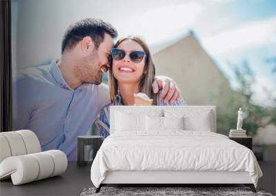 Happy couple having date and eating ice cream after shopping Wall mural