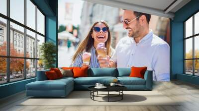 Happy couple having date and eating ice cream after shopping Wall mural