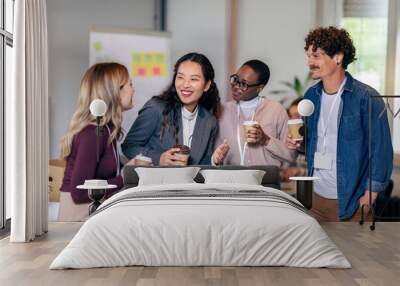 Happy diverse colleagues have fun at lunch break in office, smiling multiracial employees laugh and talk  drinking coffee Wall mural