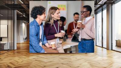 Happy diverse colleagues have fun at lunch break in office, smiling multiracial employees laugh and talk  drinking coffee Wall mural