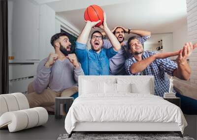 Happy friends or basketball fans watching basketball game on tv and celebrating victory at home.Friendship, sports and entertainment concept. Wall mural