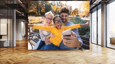 Happy young mixed race couple spending time with their daughter Wall mural