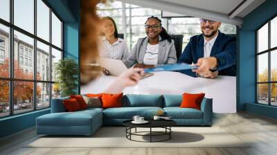 Human resource having a pleasant talk with a young female applicant in a relaxed atmosphere during an interview for a job. Wall mural