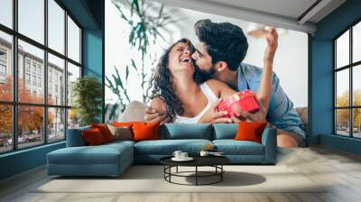 Man giving a surprise gift to woman at home Wall mural