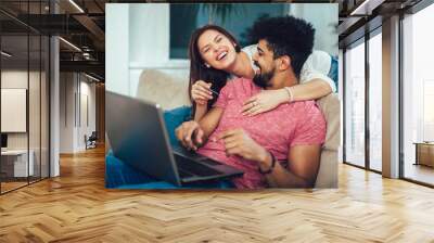 man using laptop and woman holding credit card. young couple shopping online with credit card at hom Wall mural