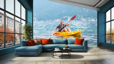 Mature man kayaking on the sea Wall mural