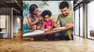 Mom and dad drawing with their daughter. African american family spending time together at home. Wall mural