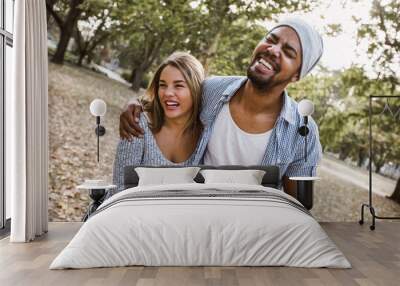 Outdoor portrait of romantic and happy mixed race young couple in park Wall mural