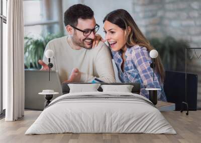 Smiling couple using digital tablet and credit card at home Wall mural