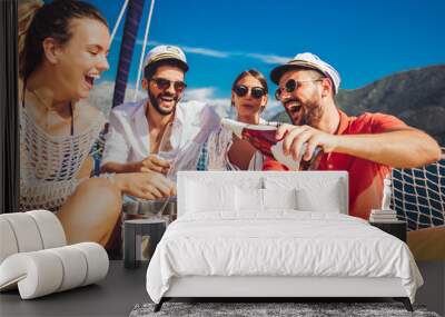 Smiling friends with glasses of champagne on yacht. Vacation, travel, sea, friendship and people concept Wall mural