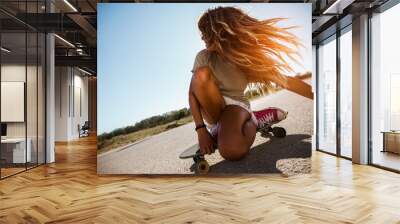 Sporty woman riding on the skateboard on the road. Longboarding, female. Wall mural