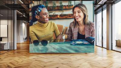 Two female friends talking at a coffee shop Wall mural