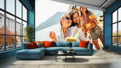 Young friends having fun at the beach on a sunny day. Wall mural