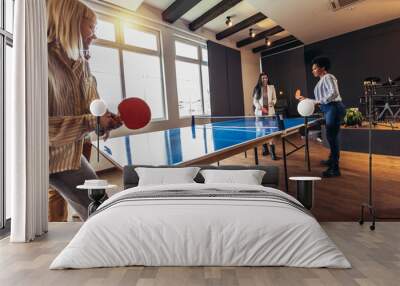 Young people playing table tennis in the office at work Wall mural