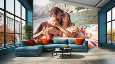 Young trendy couple having fun swimming in summer vacation Wall mural