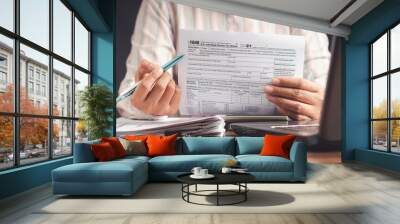 Businesswoman showing a tax form to complete individual income tax payment form Wall mural