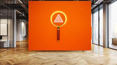 Exclamation mark and warning text on a magnifying glass over an orange background. Wall mural