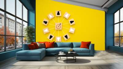 Wooden cubes with people icons focus on the goal over a yellow background Wall mural