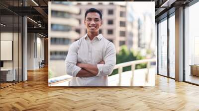 a young attractive asian man stands in front of city buildings with arms crossed Wall mural