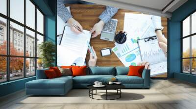 Businessmen at their desk sign contract and shake each other Wall mural