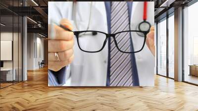 Male medicine doctor hands giving pair of black glasses Wall mural