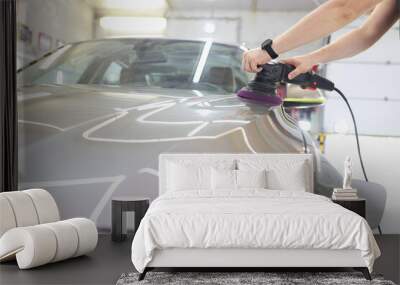 Man in silver car polishing surface with polishing gel Wall mural